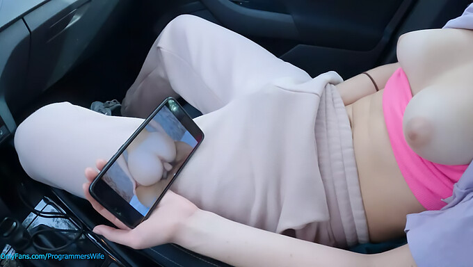 A young girl pleasures herself in a public parking lot while watching her adult content - ProgrammersWife